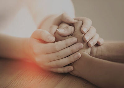 Two people holding hands resting on a desk